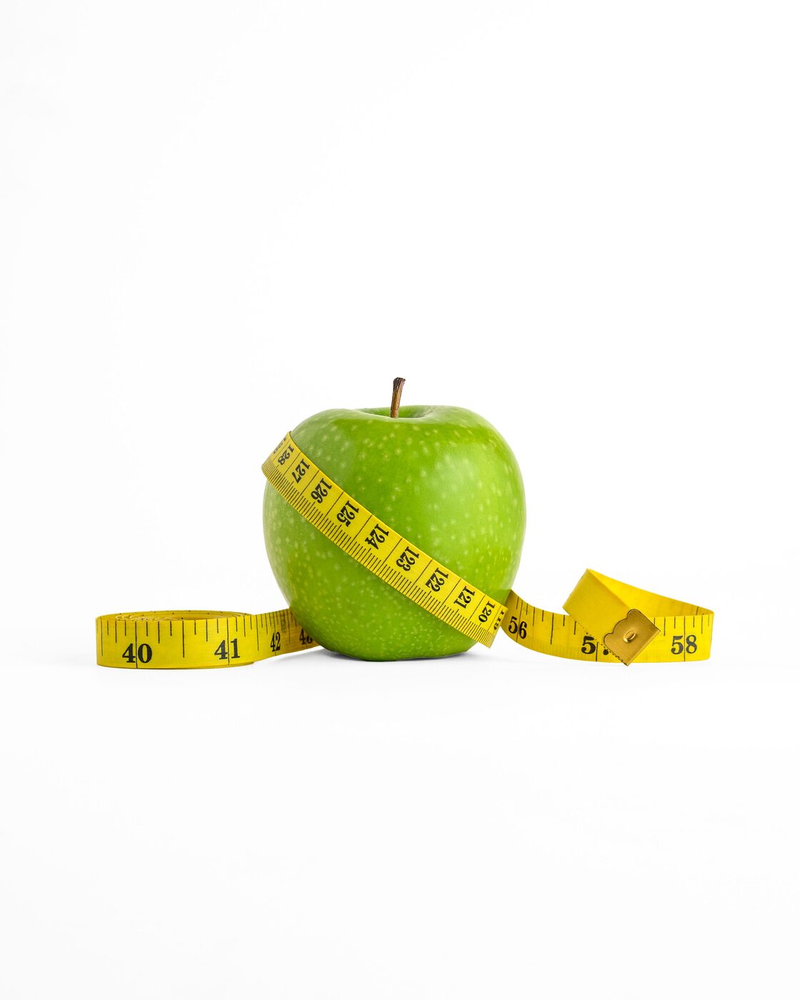 Pomme verte entourée d'un mètre ruban, symbole du suivi de la perte de poids